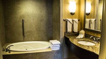 A modern bathroom with a bathtub, a sink, and a mirror.
