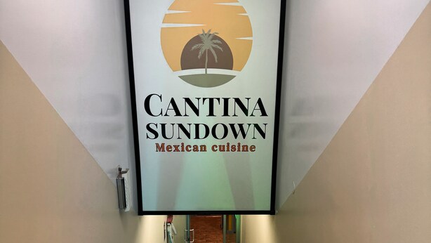 A hallway with a sign for Cantina Sundown Mexican cuisine, leading to a room with a wooden floor and a door. - Holiday Inn NYC - Lower East Side by IHG (New York)