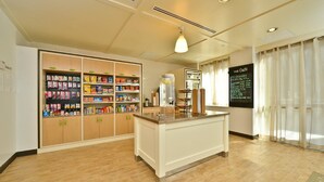 A hotel lobby with a reception desk, a large beverage dispenser, and a menu board. - Holiday Inn NYC - Lower East Side by IHG (New York)