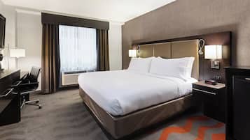 Una habitación de hotel con cama, escritorio, silla y televisor.