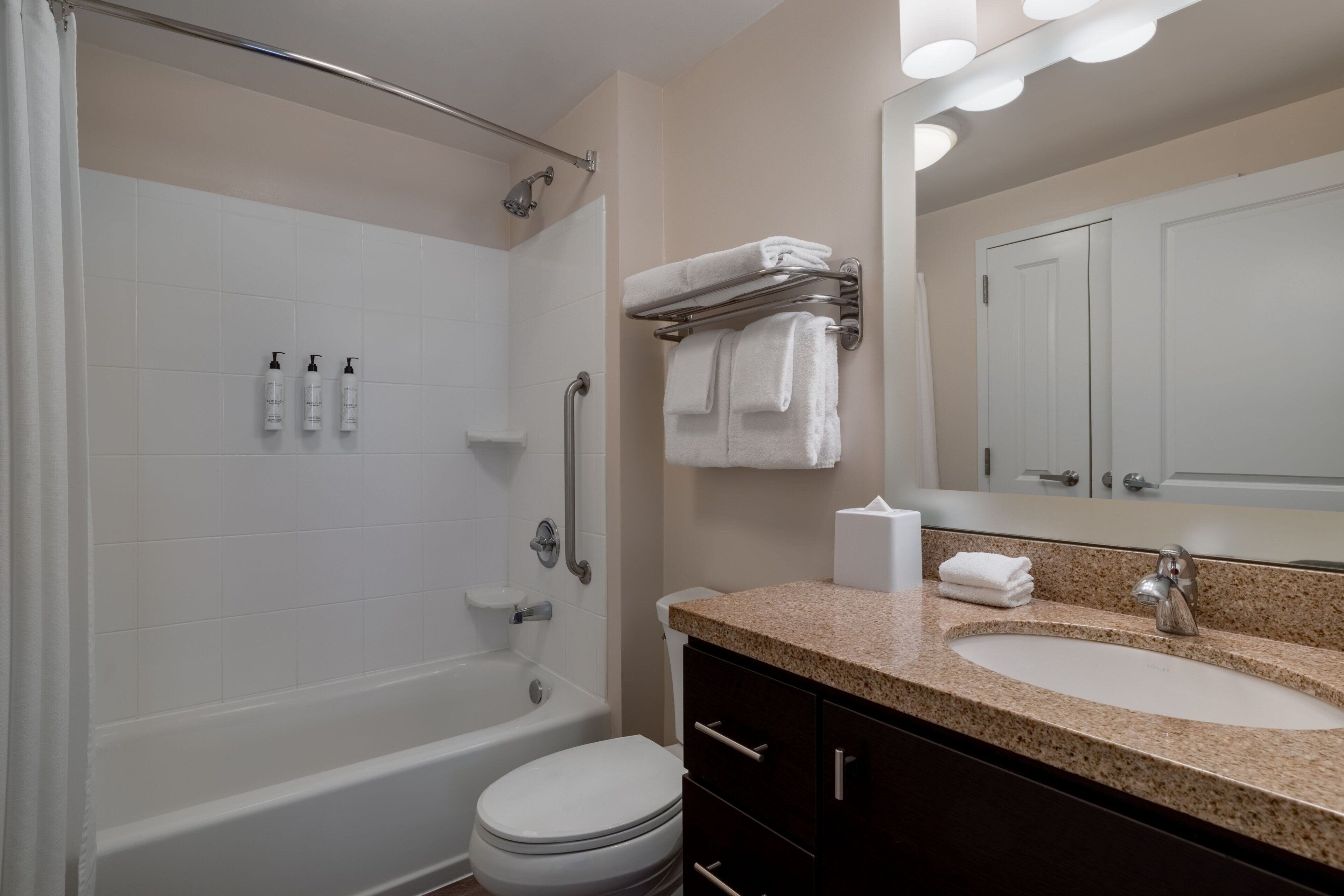 Une salle de bain avec une baignoire, des toilettes, un lavabo et un miroir.