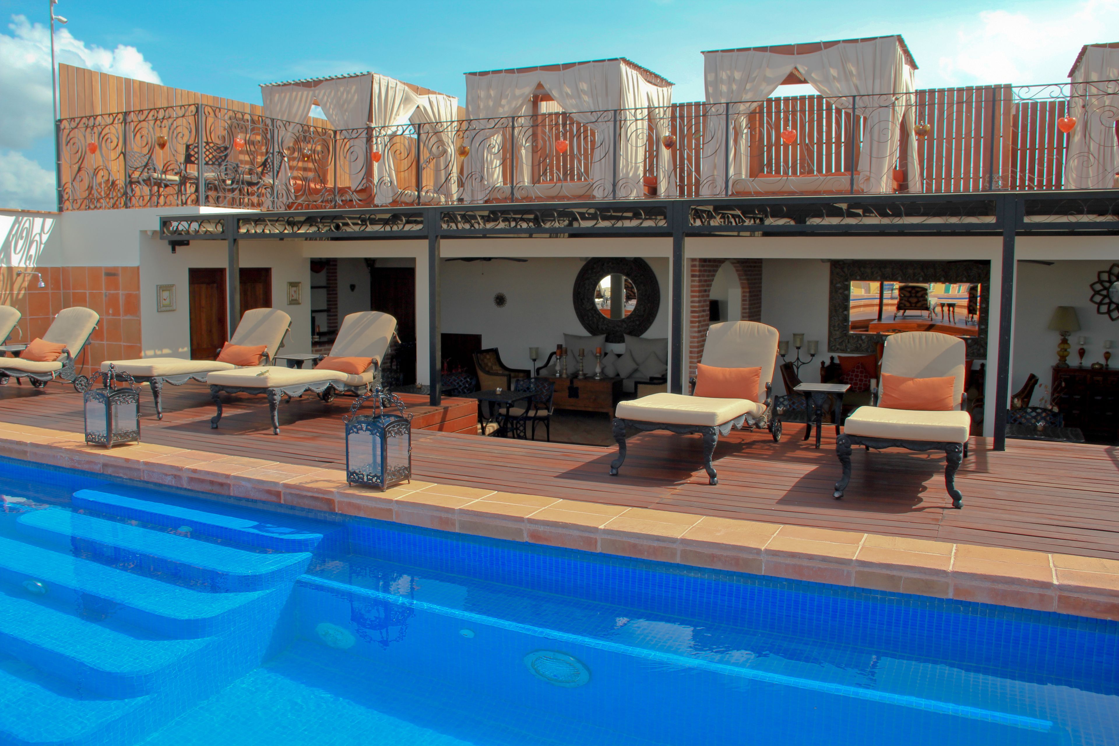 A poolside area with lounge chairs and a covered seating area.