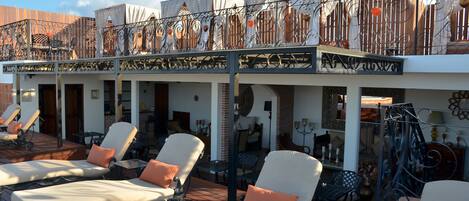 Un espace de détente aménagé sur le toit, avec des chaises longues et une terrasse couverte.