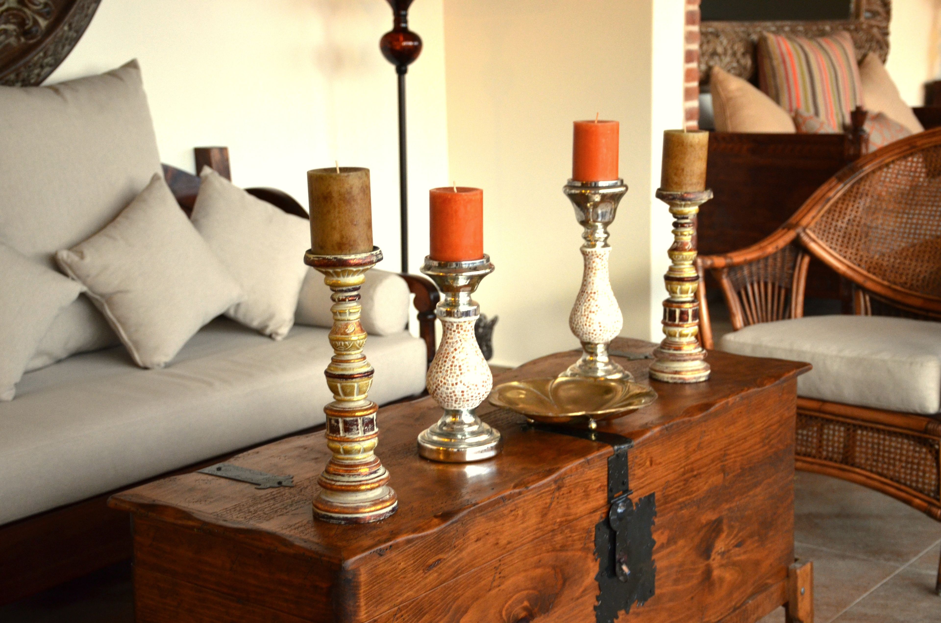 A wooden chest with ornate candle holders and a brass tray.