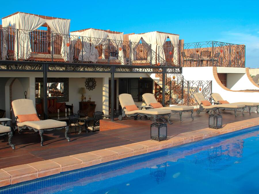 A poolside area with lounge chairs and a covered seating area.