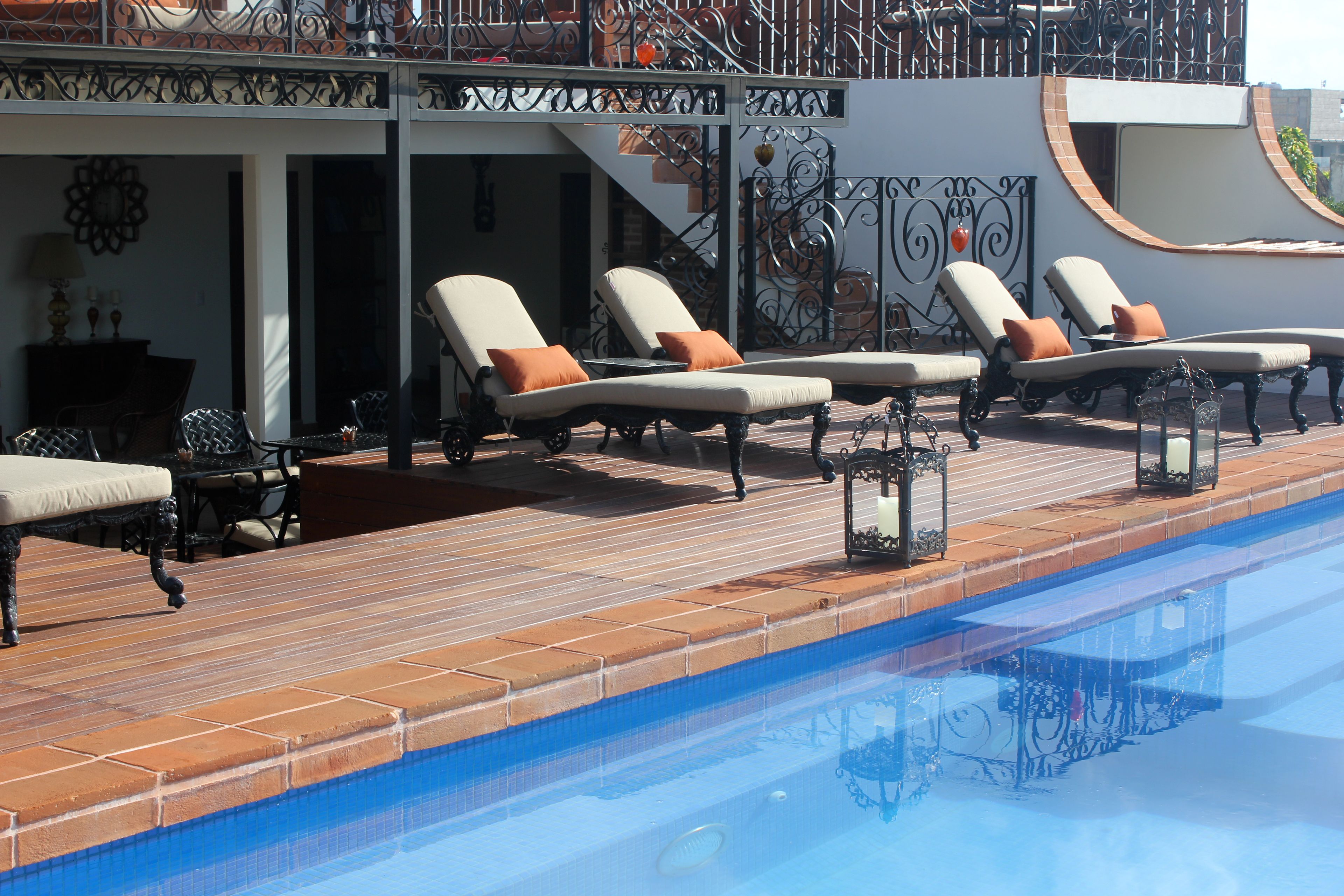 A poolside area with lounge chairs and a brick deck.