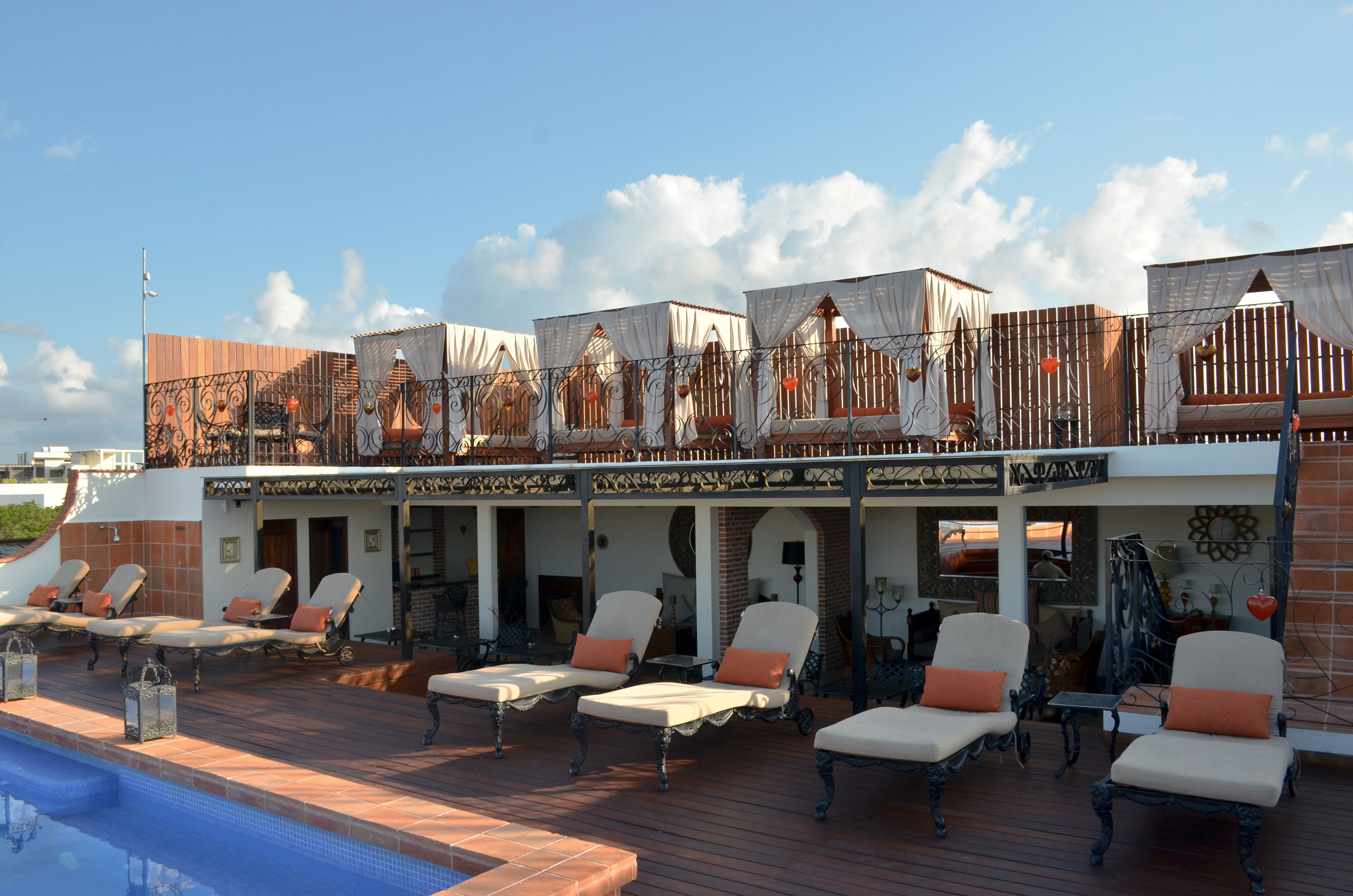A rooftop pool area with sun loungers and a pool.