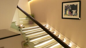 Una escala moderna amb barana de vidre i barana de fusta, que condueix a un pis superior.