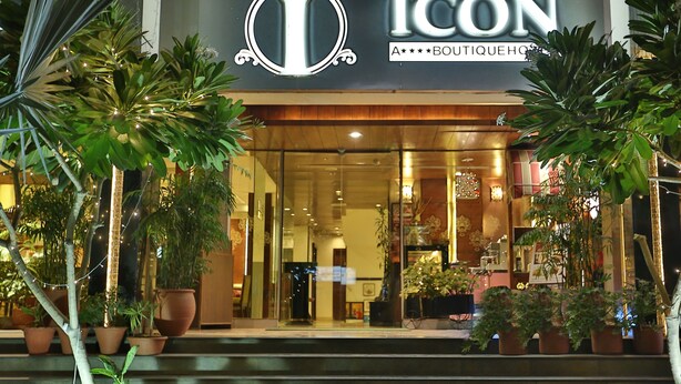 Entrada d'un hotel boutique amb un logotip destacat, unes escales que condueixen a l'entrada i plantes en testos a banda i banda.