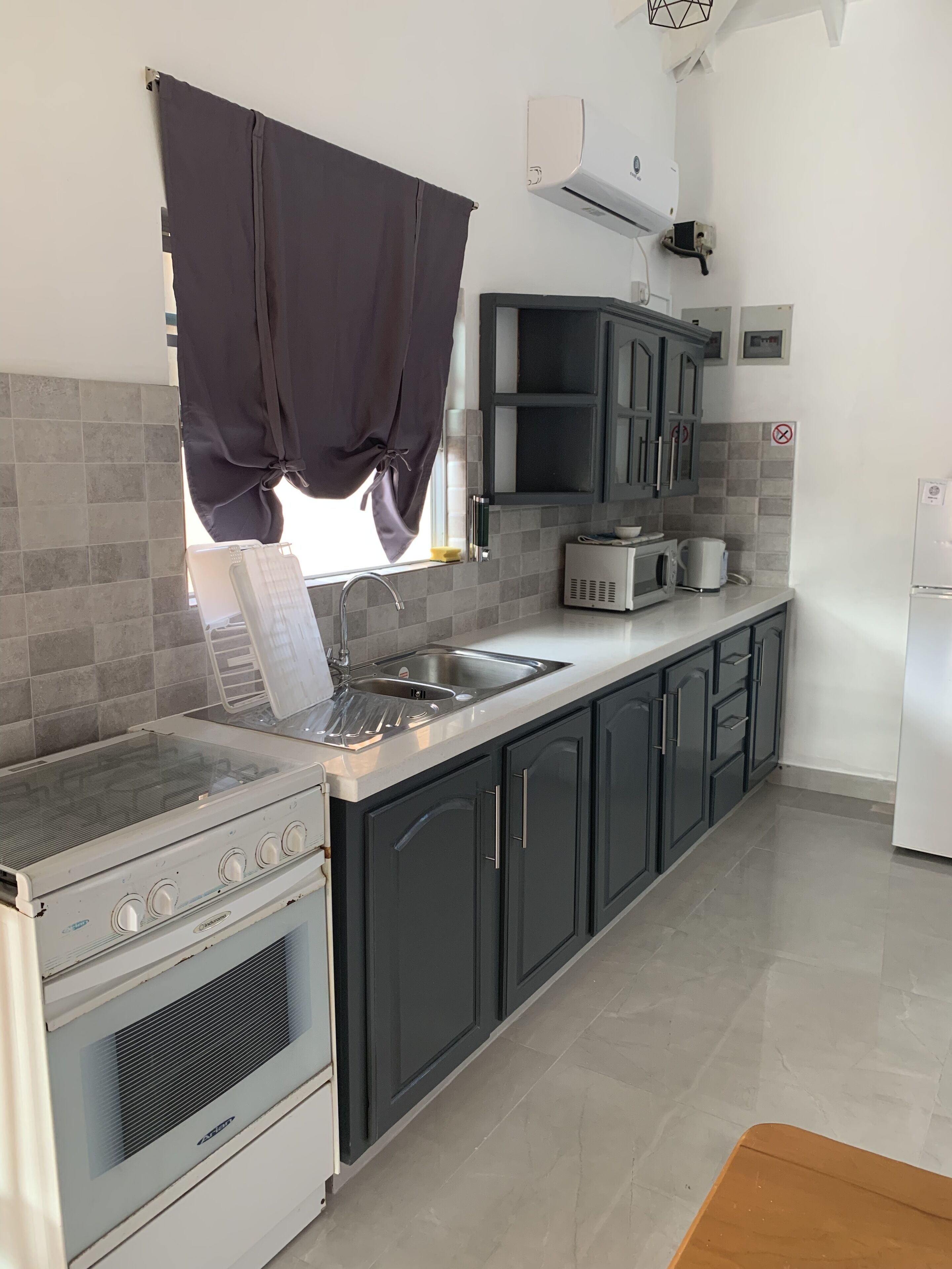 A modern kitchen with a built-in stove, a sink, and dark cabinets.