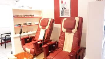 Relax in comfort with two massage chairs featuring footrests and control panels.