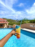 Una piscina al aire libre, sillones reclinables de piscina