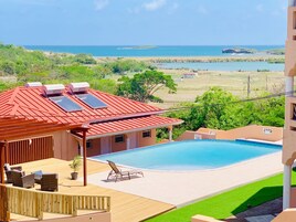 Una piscina al aire libre, sillones reclinables de piscina
