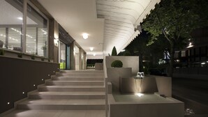Una escalera moderna de diseño minimalista que lleva a una zona de descanso con fuente decorativa.