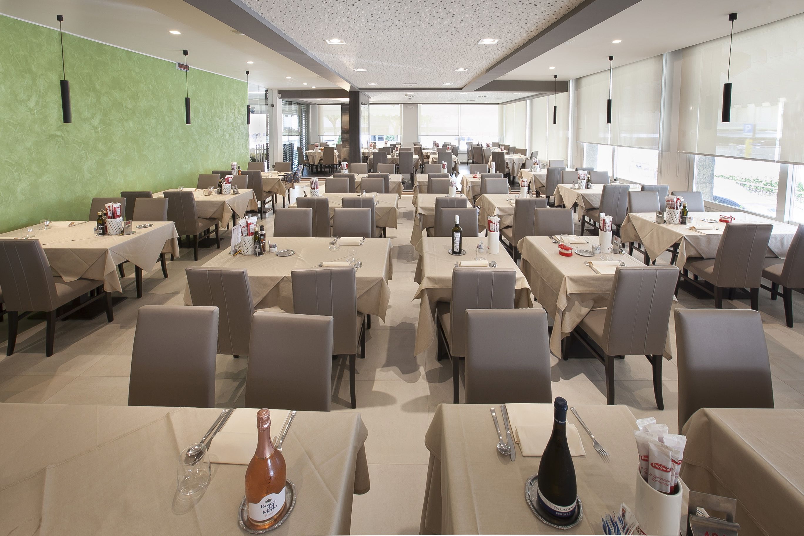 A spacious dining area with multiple tables and chairs, arranged in rows.