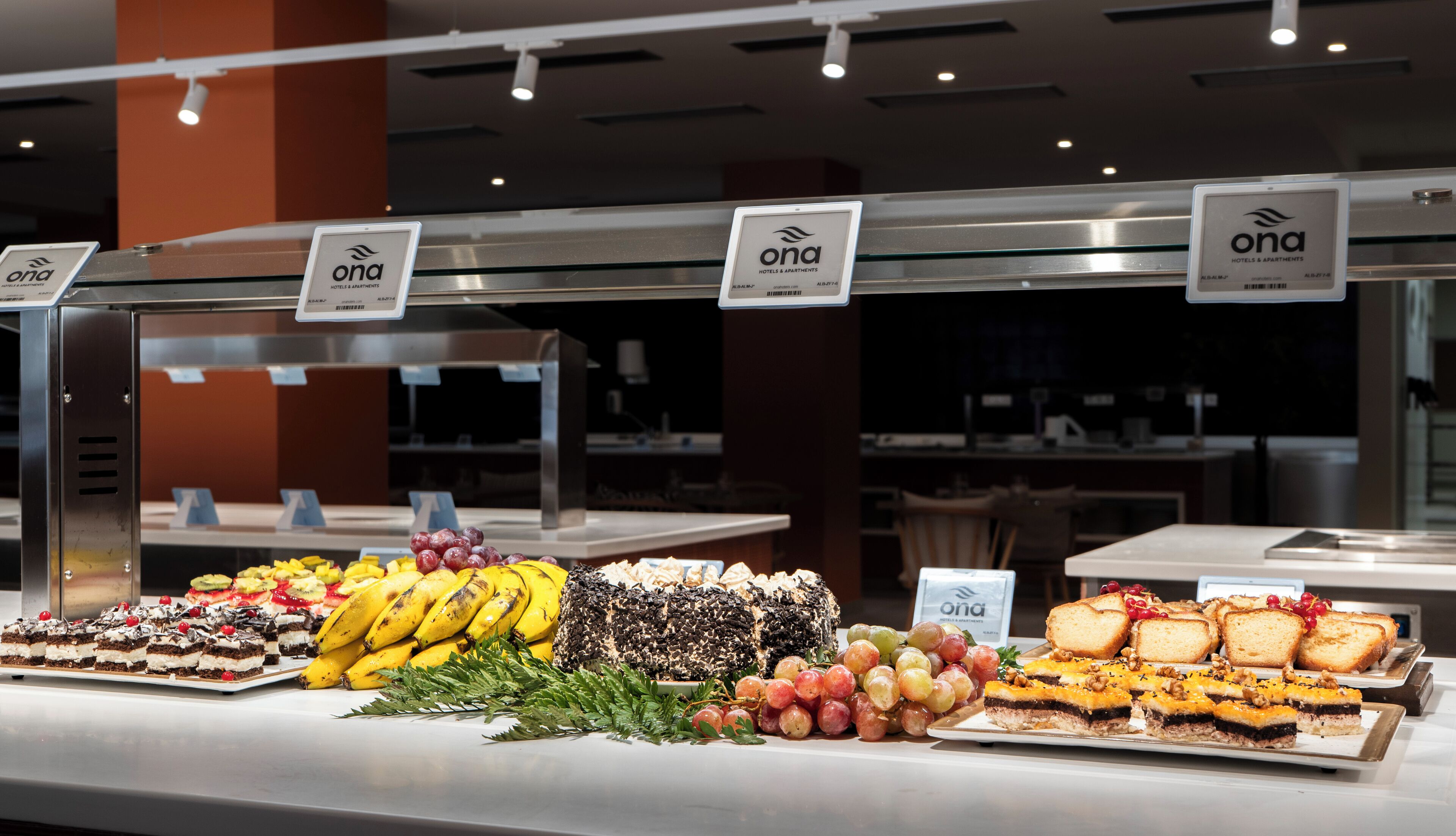 A buffet with various food items including fruits, cakes, and pastries.