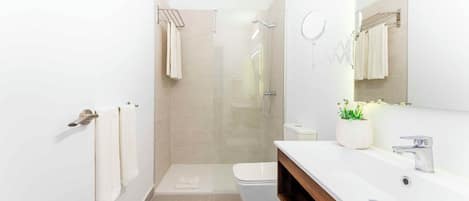 A modern bathroom with a shower, toilet, and vanity.
