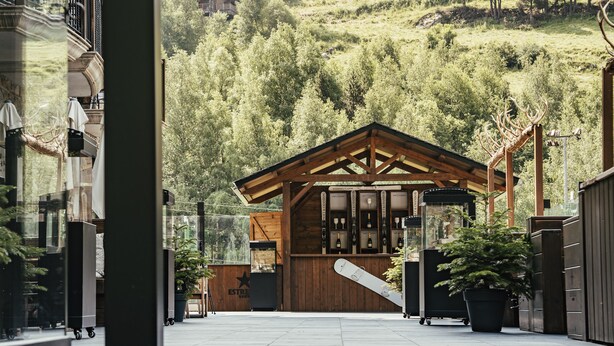 A ski lodge with a wooden facade, a ski lift, and a mountain backdrop. - Serras Andorra (Soldeu)
