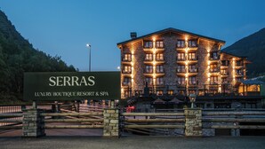 A luxury boutique resort with a stone facade, multiple balconies, and a sign indicating it is a spa and resort. - Serras Andorra (Soldeu)