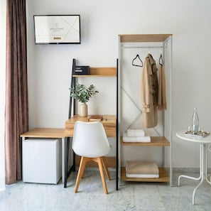 A modern, minimalist room with a desk, chair, wardrobe, and a small table with a bottle and glasses. - Melo Accommodations (Bari)