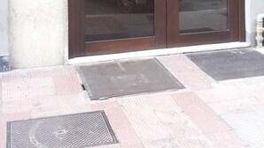 A building entrance with a glass door, a number '195' above it, and a sign on the wall to the left. - Melo Accommodations (Bari)