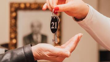A person handing over a key with a number tag to another person.