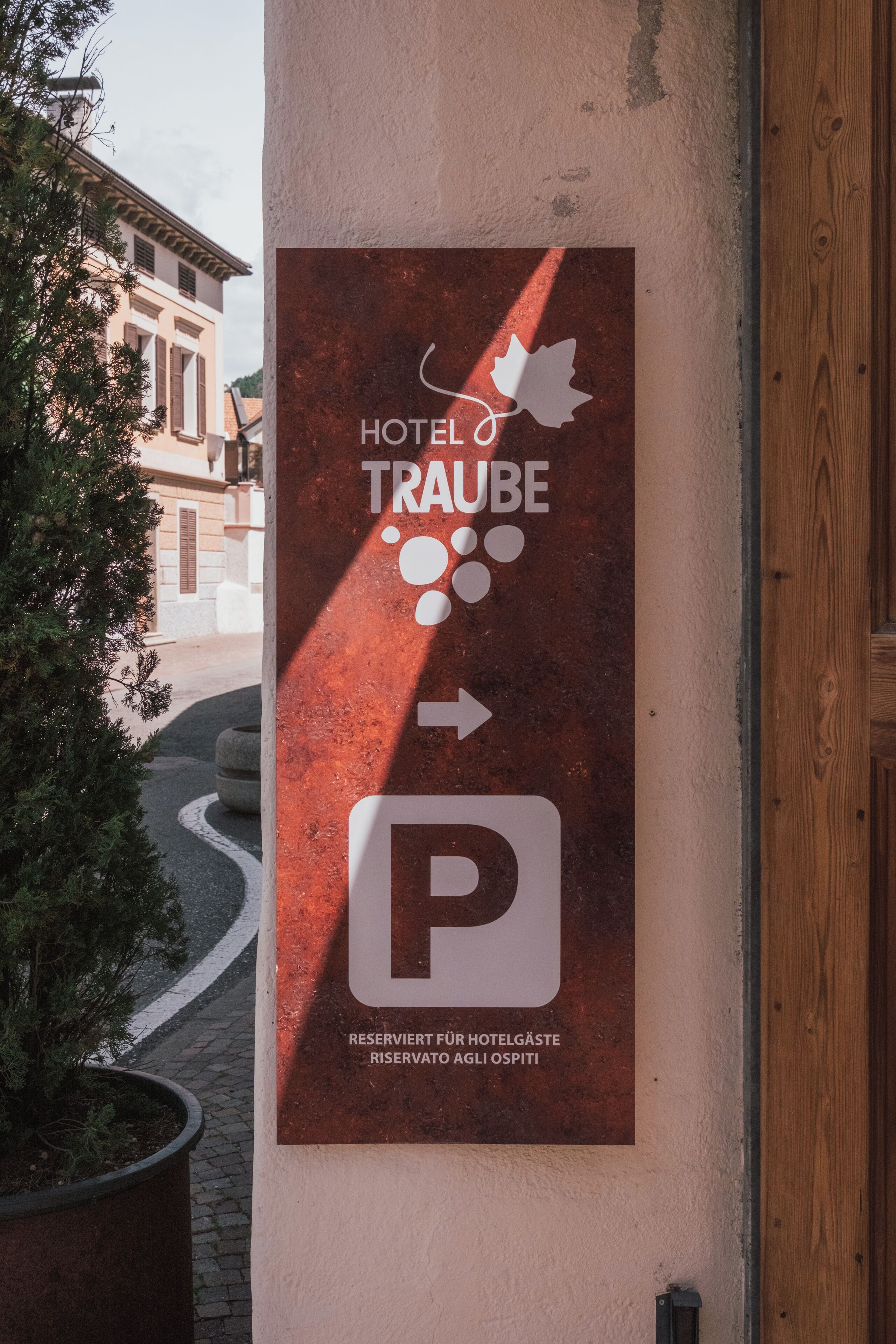A hotel sign with a directional arrow and a parking symbol, indicating a reserved parking area for hotel guests.