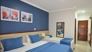 A hotel room with two beds, a nightstand, a mirror, and two framed pictures on the wall. - Taiyo Thermas Hotel (Caldas Novas)