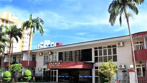 A hotel with a red and white facade, air conditioning units, and a gated entrance. - Taiyo Thermas Hotel (Caldas Novas)