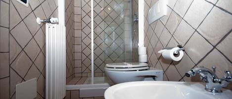 A bathroom with a shower, toilet, and sink.