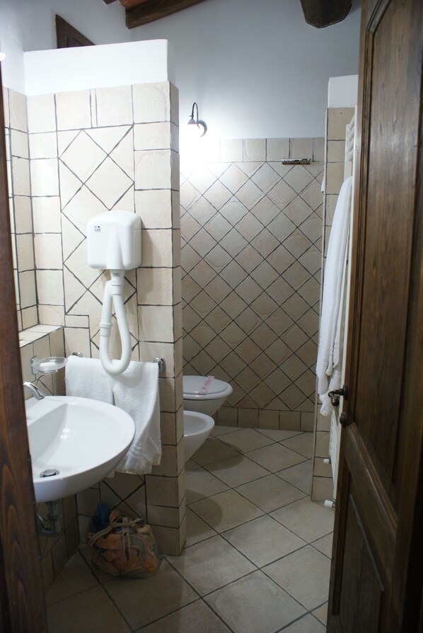 A bathroom with a sink, toilet, and shower.