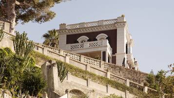 A building with a staircase leading up to a balcony with ornate railings.