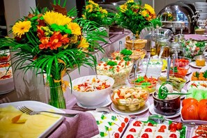 A buffet table with various dishes, including salads, desserts, and beverages, arranged on a table with a purple tablecloth. - Hotel Dwór Elizy blisko Sky Bridge (Bystrzyca Klodzka)