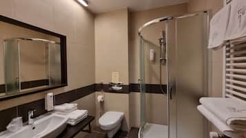 Un baño moderno con lavabo, inodoro y ducha con mampara de vidrio.