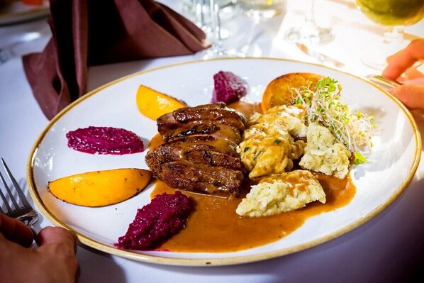 Un plato de comida con carne, puré de papas y vegetales.