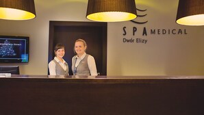A reception area with a sign for SPA MEDICAL, a reception desk, and a television displaying a Christmas tree.