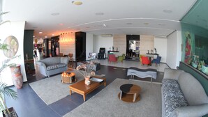 Uma sala de estar moderna com sofá, poltronas, mesa de centro e lareira.