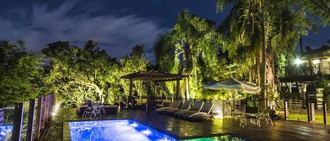 Una piscina al aire libre, sillones reclinables de piscina