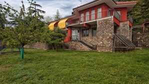 A two-story house with a stone foundation, a red and yellow exterior, and a balcony. - Oasi Verde (Castiglione Chiavarese)