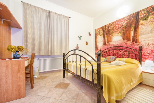 A bedroom with a bed, a desk, and a radiator. - Oasi Verde (Castiglione Chiavarese)