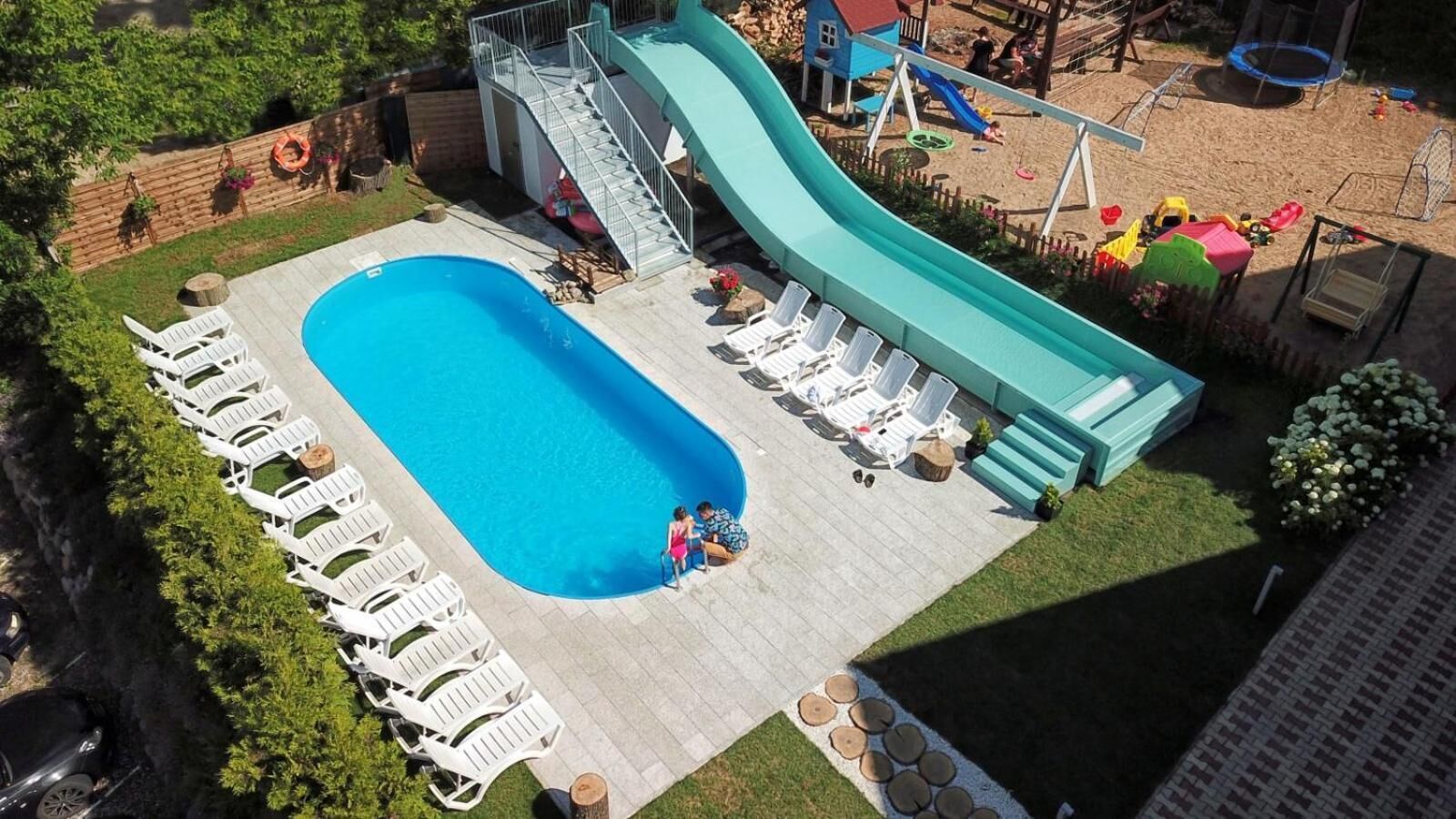 Una piscina al aire libre, sillones reclinables de piscina