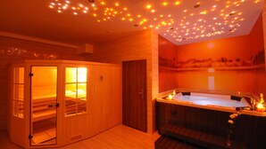 A sauna room with a wooden cabinet, a hot tub, and a mural on the wall. - Hotel Santa Monica (Mikolajki)