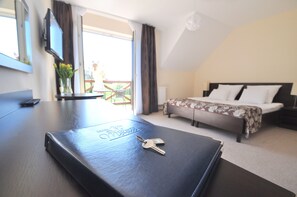 A hotel room with a bed, a desk with a laptop, and a view of the outdoors. - Hotel Santa Monica (Mikolajki)