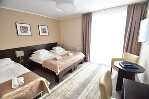 A hotel room with two beds, a desk, and a chair. - Hotel Santa Monica (Mikolajki)