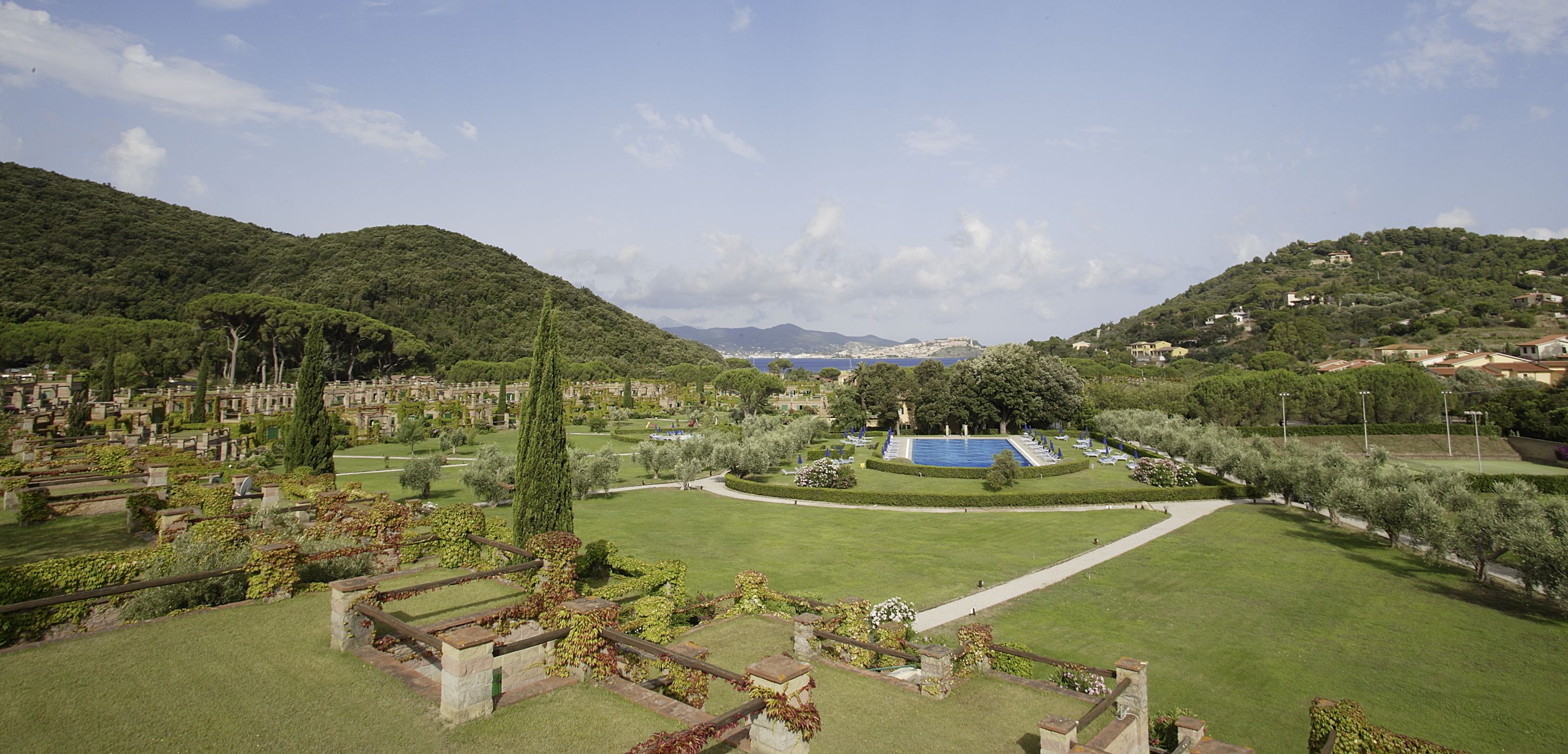 A landscaped garden with a central pool, pathways, and surrounding greenery.