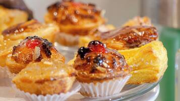 A plate of pastries with a glossy glaze and fruit toppings.