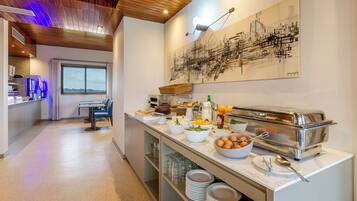 A modern kitchen with a buffet setup, including various food items and a toaster.