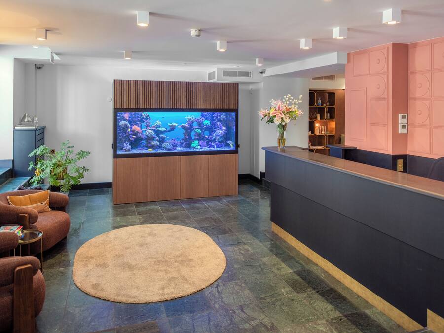 Un área de recepción con un gran acuario, asientos cómodos y un diseño moderno.