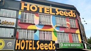 A building with a colorful facade, featuring signs for 'HOTEL Seeds' and 'SITI BISTRO'. - Seeds Hotel Shah Alam Seksyen 7 I-City (Shah Alam)