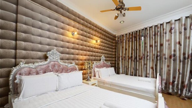A hotel room with two beds, a ceiling fan, and a large window with curtains. - Seeds Hotel Shah Alam Seksyen 7 I-City (Shah Alam)